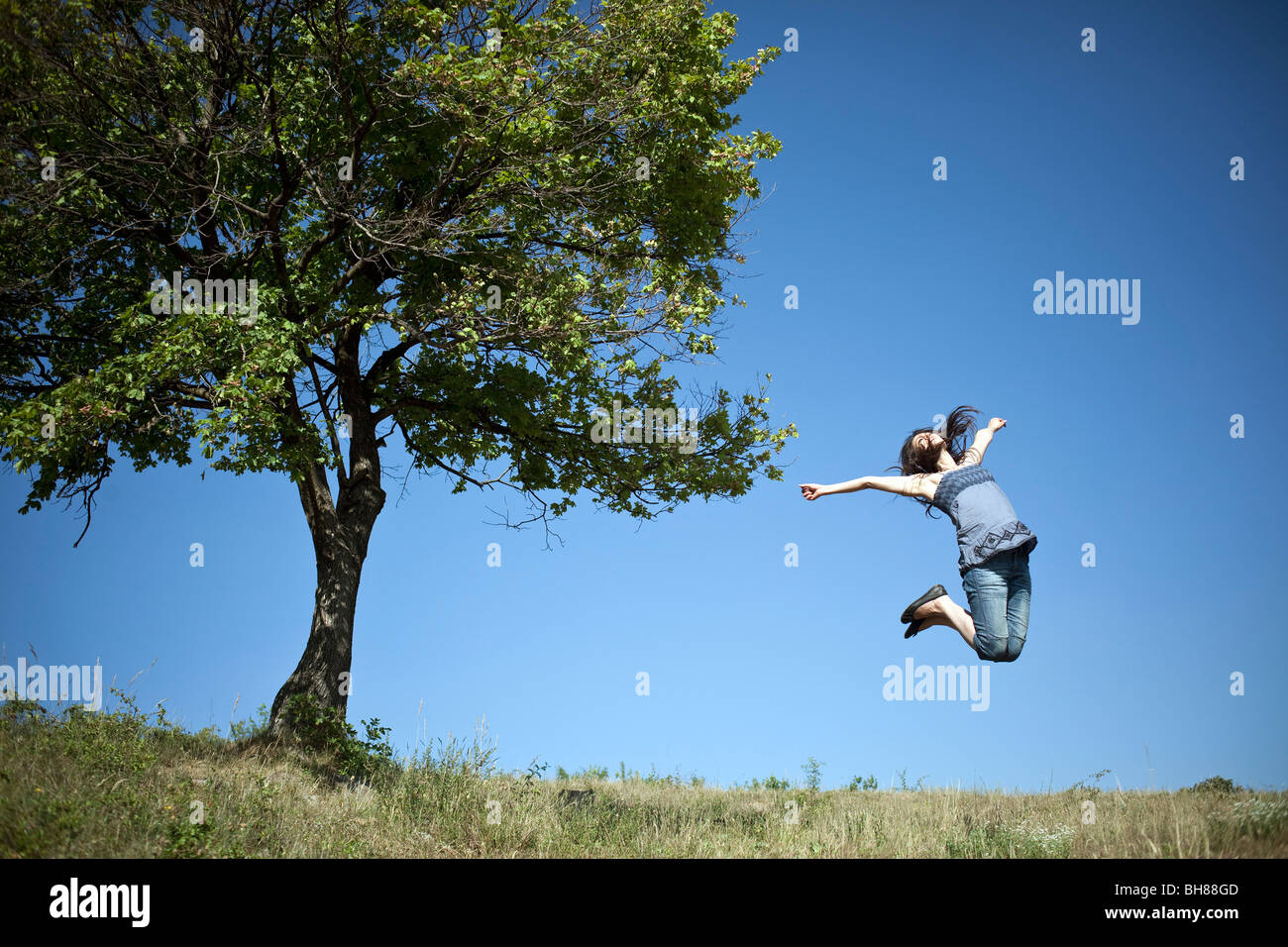 Frau springt von Baum Stockfoto
