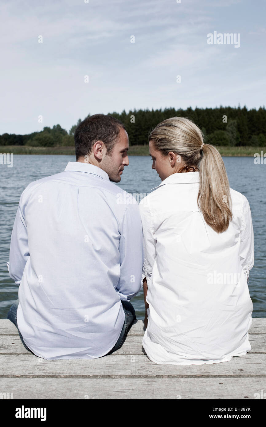Ein paar sitzt auf einem Steg Stockfoto