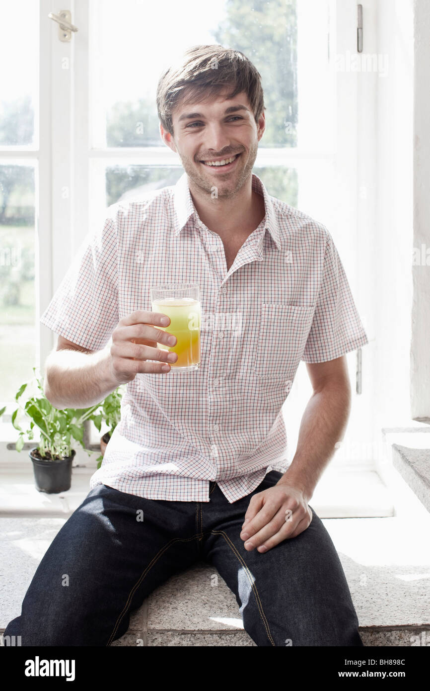 Ein Mann hält ein Glas Saft und lächelnd Stockfoto