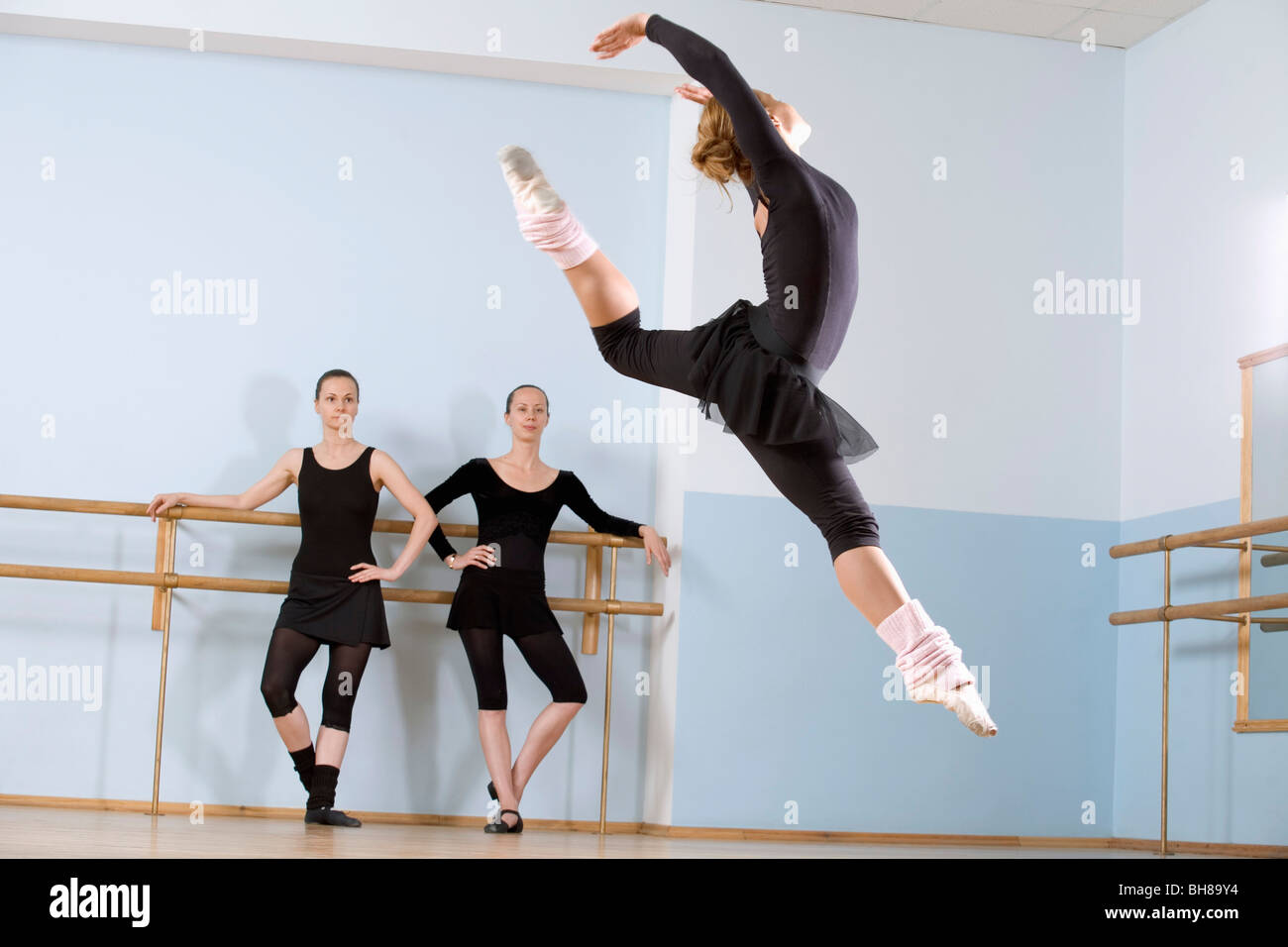 Sprung durch die Luft wie zwei weitere Frauen schauen auf ballerina Stockfoto