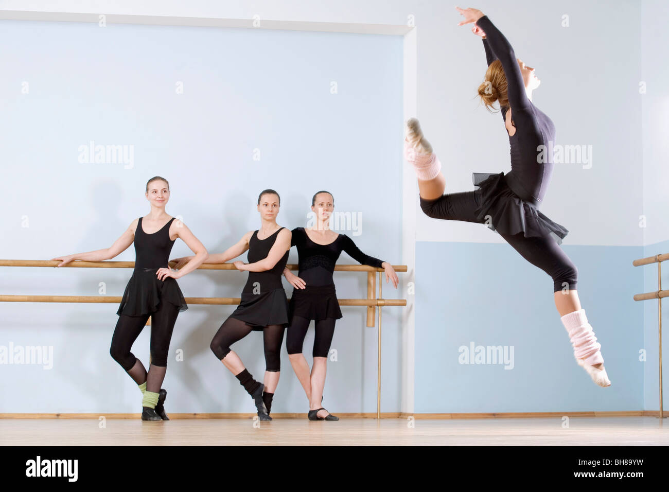 Sprung durch die Luft wie drei andere Frauen schauen auf ballerina Stockfoto
