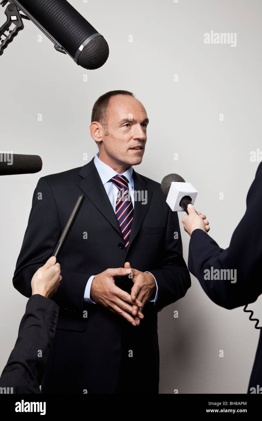 Ein Mann in einem Anzug wird von den Medien interviewt Stockfoto