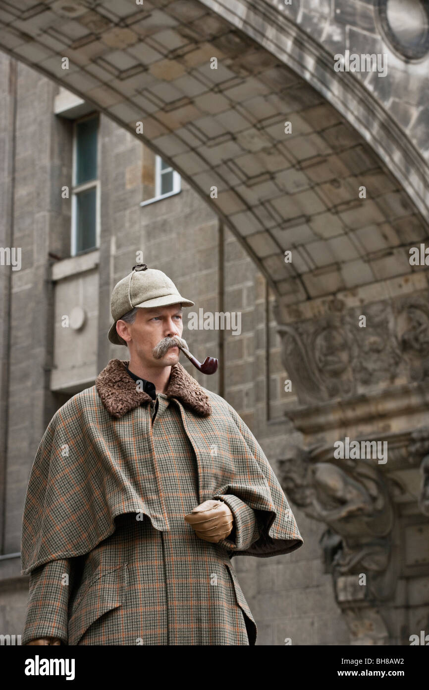 Ein Mann verkleidet als Sherlock Holmes stehen unter einem Gebäude Bogen wegschauen Stockfoto