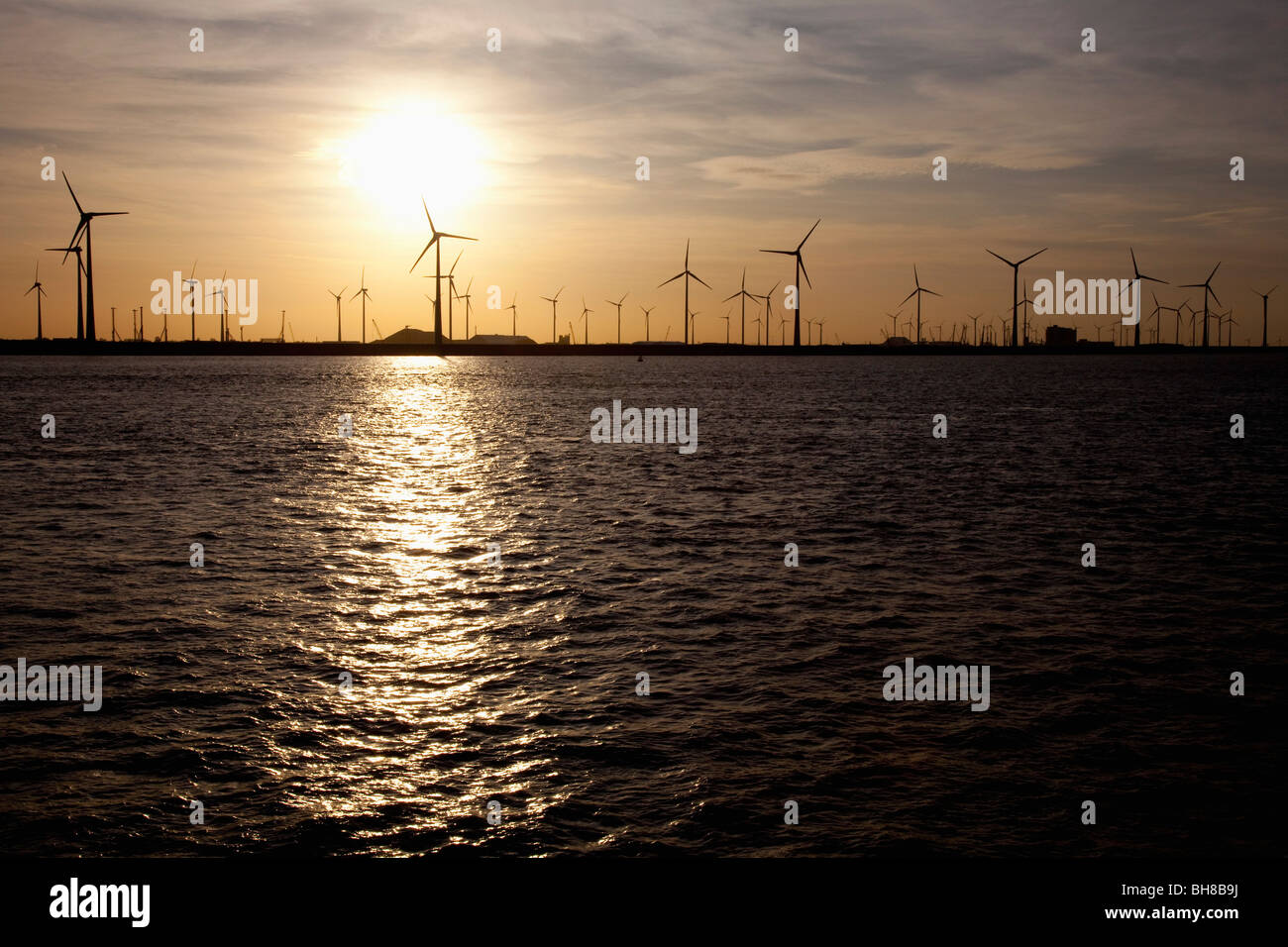 Ansicht von Windenergieanlagen über Wasser bei Sonnenuntergang Stockfoto