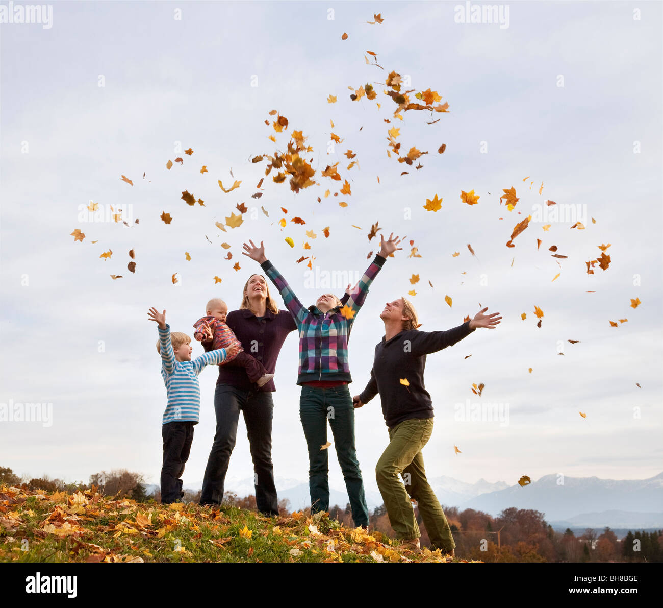 Familie Herbst wirft Blätter in Luft Stockfoto