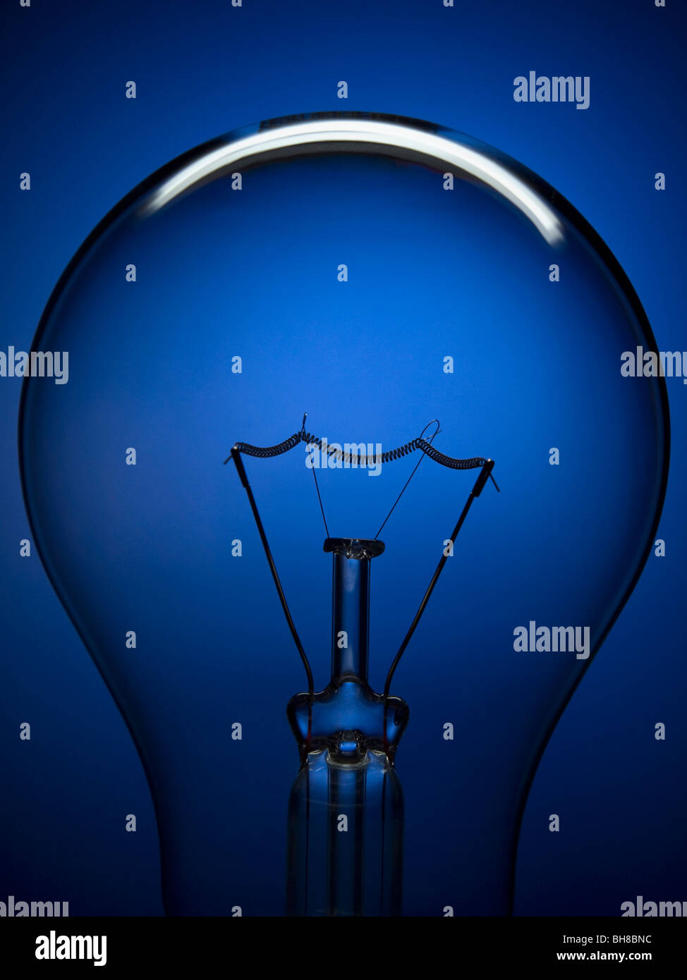 Hautnah auf eine transparente Glühbirne über einen blauen Hintergrund. Stockfoto