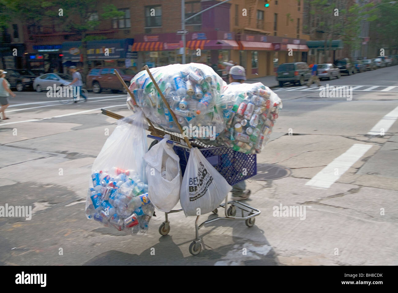 Man sammelt Aluminiumdosen in Lebensmittel-Korb in upper Eastside von New York Stockfoto