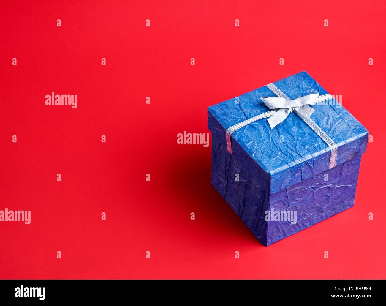 Blaues Geschenk auf rotem Grund Stockfoto