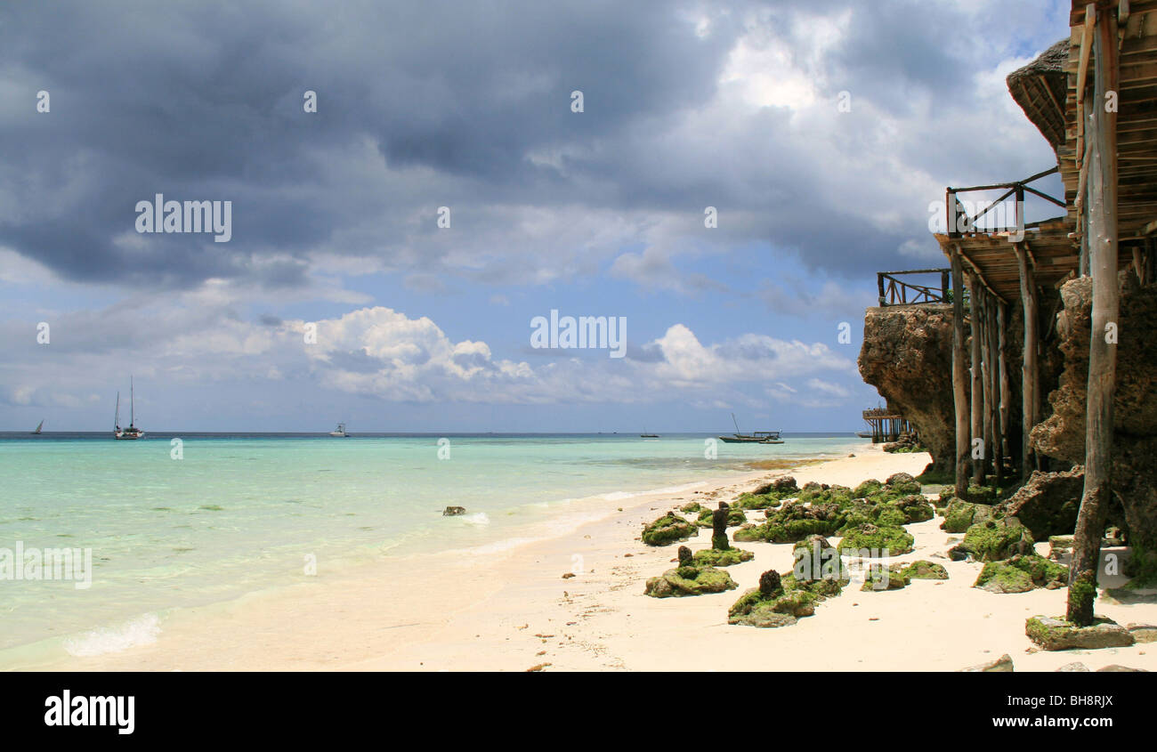 die hölzerne Piers von den Strandrestaurants Eingreifen auf dem weißen Sand Strand und türkis Wasser von Nungwi in Sansibar Stockfoto
