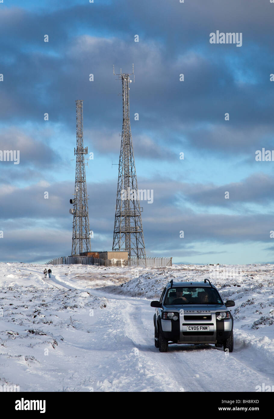 Land Rover Fahrzeug auf verschneiten Straße auf Moorland mit Antenne Masten im Winter Blorenge Wales UK Stockfoto