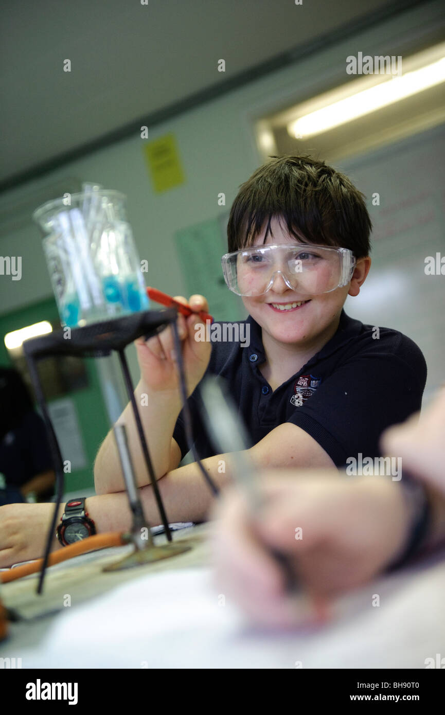 Junge Teenager in Wissenschaft Schulklasse, UK, mit Sicherheit Brille, beobachten experiment Stockfoto