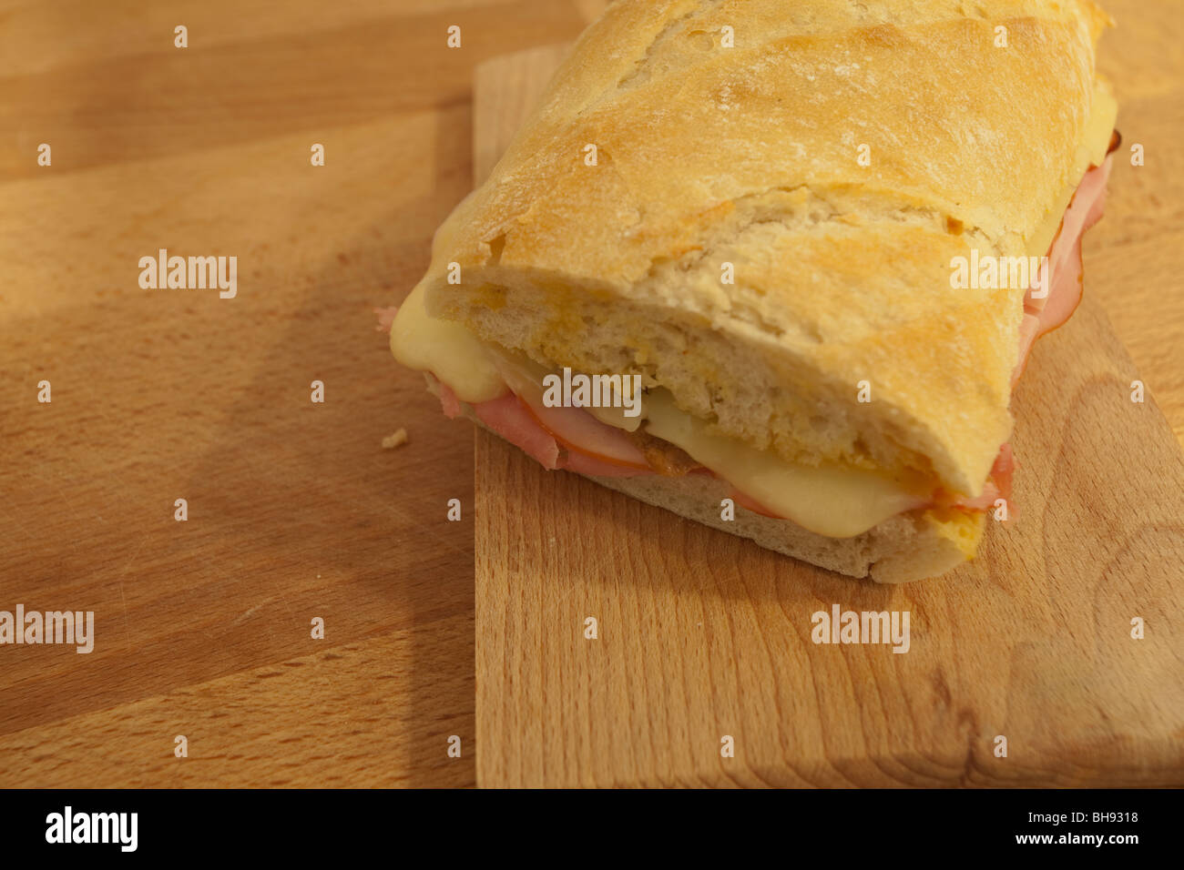 Kubanisches Sandwich mit Schinken, Käse und Gurken auf einem Holzbrett. Stockfoto