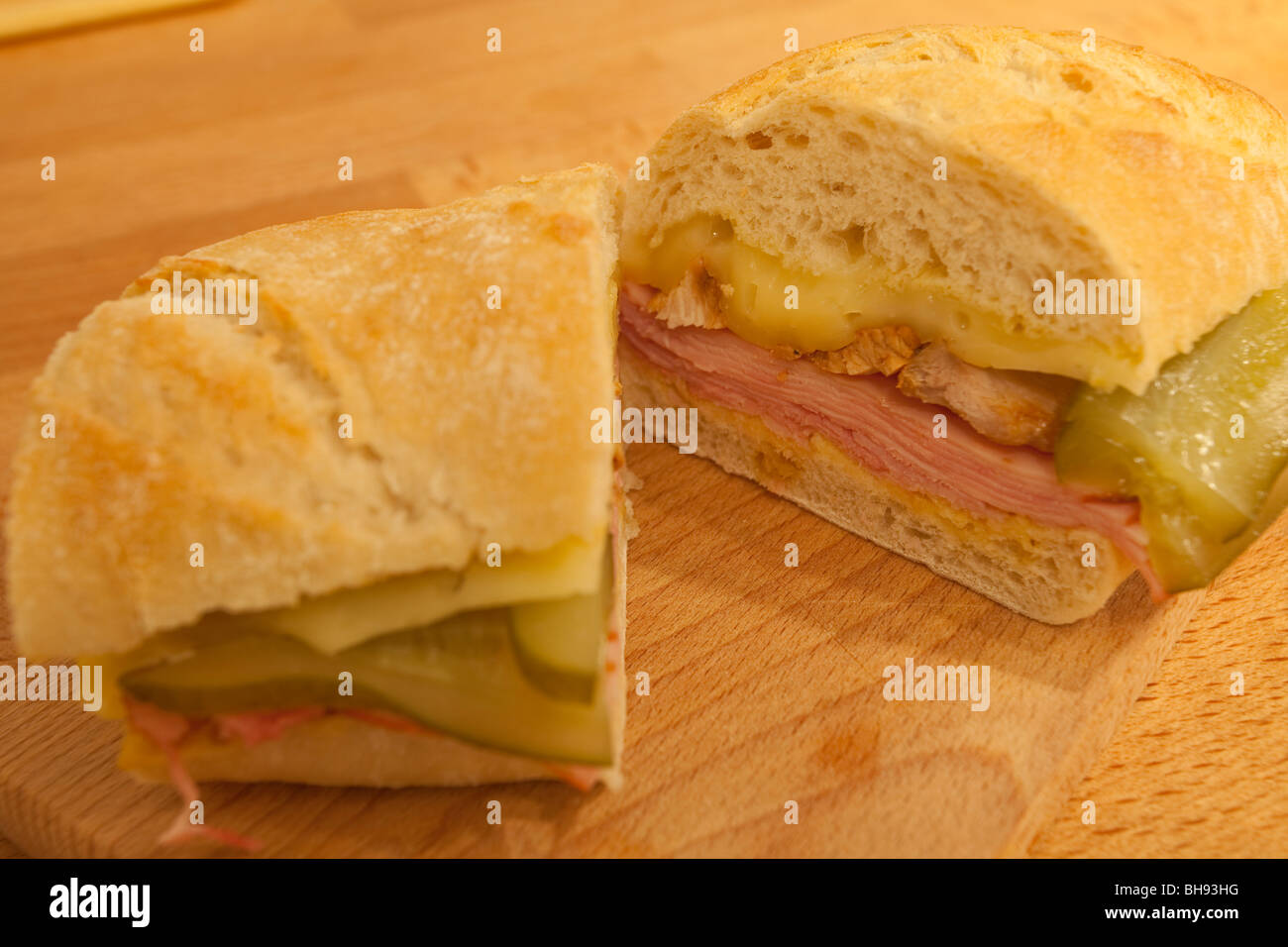 Kubanisches Sandwich mit Schinken, Käse und Gurken auf einem Holzbrett. Stockfoto
