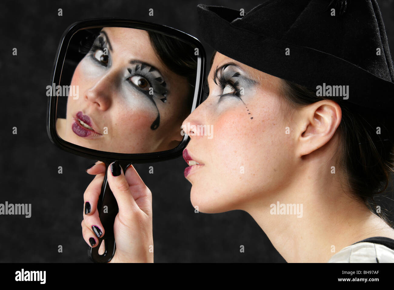 Junge Frau Blick auf ihr Spiegelbild in einem Handspiegel Stockfoto