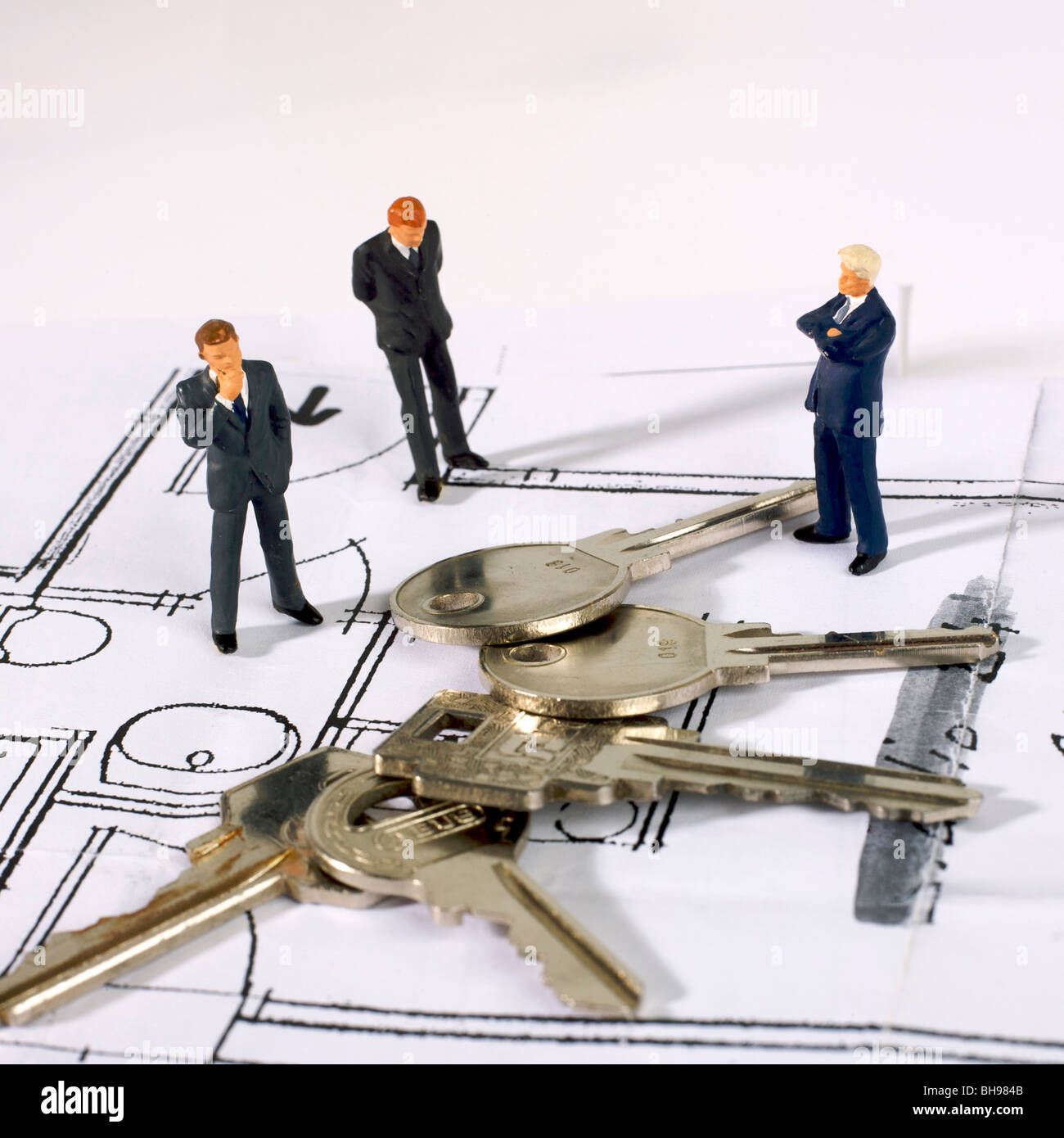 Architekten, Männer, Figuren und Schlüssel der Wohnungen auf einen Bauplan Stockfoto