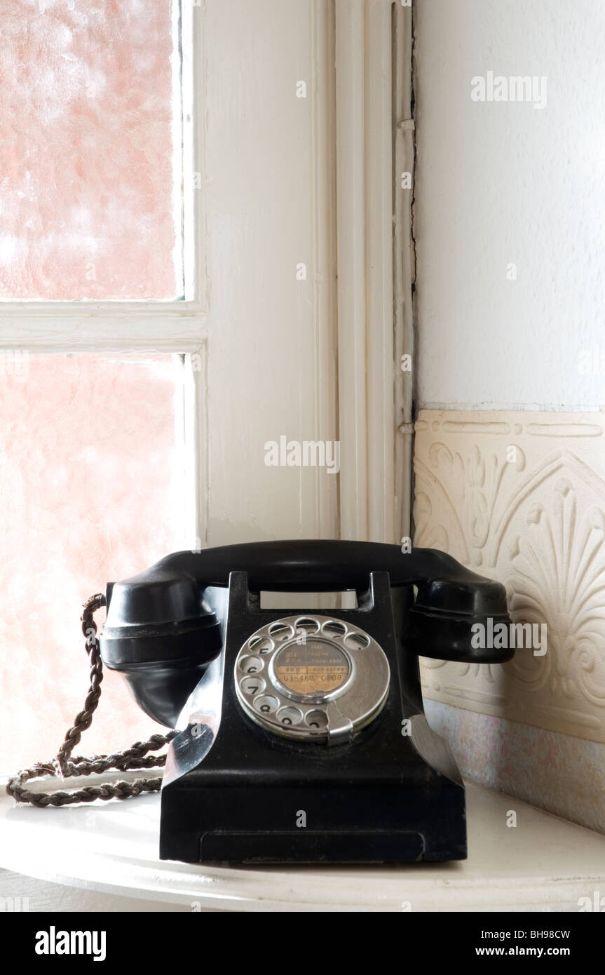 Eine altmodische Bakelit Telefon sitzt auf einem Ecktisch in einem Haus. Stockfoto