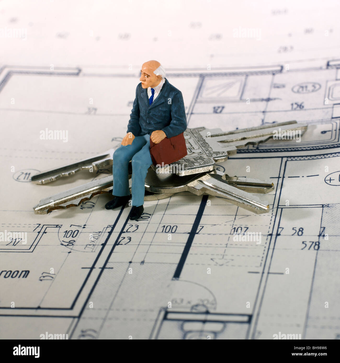 Senioren, Figur und Schlüssel von Wohnungen auf einen Bauplan Stockfoto