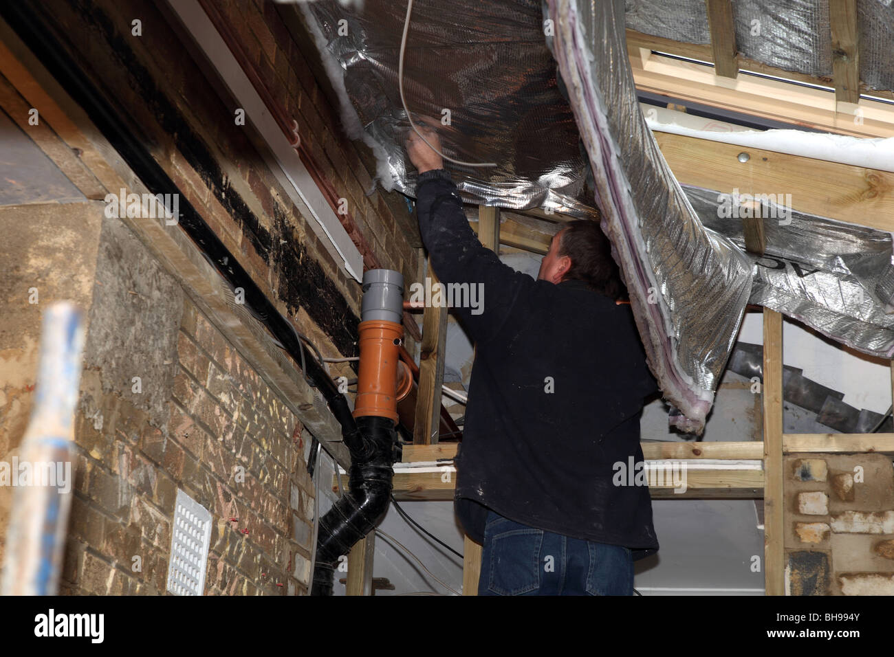 Montage der Folie Dachdämmung in eine inländische Immobilien Stockfoto