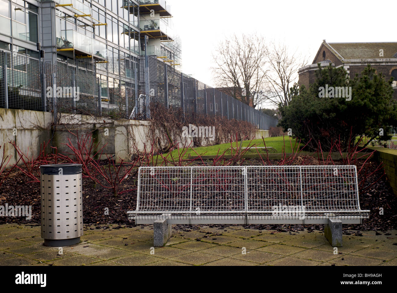 Silberne Bank neben einem silbernen Mülleimer Stockfoto