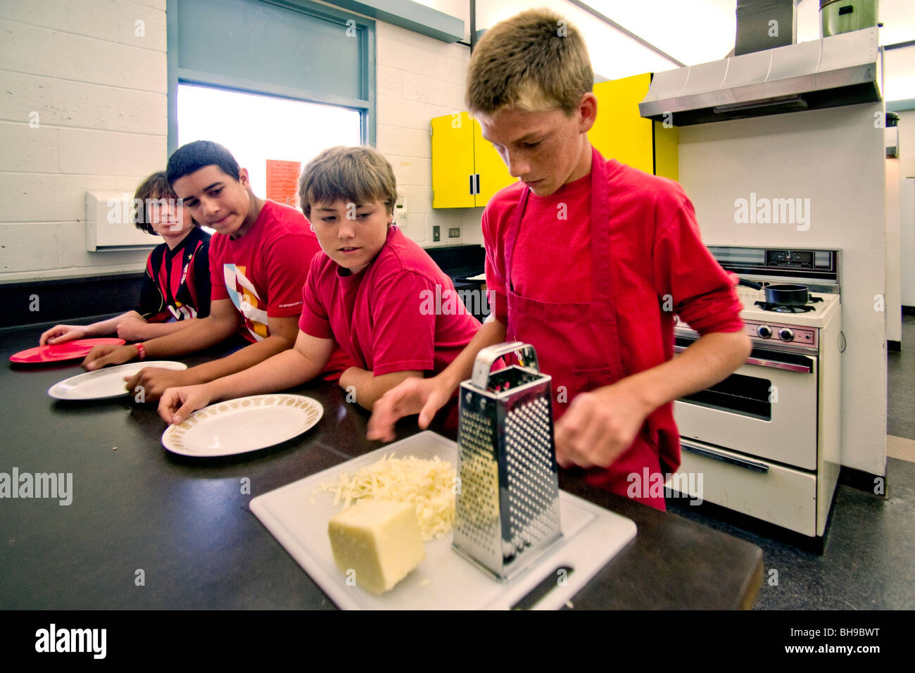 Achten Klasse jungen an einer Mittelschule in Südkalifornien bereiten Sie ein Gericht ihre Hauswirtschaft Wahlfach kochen. Stockfoto