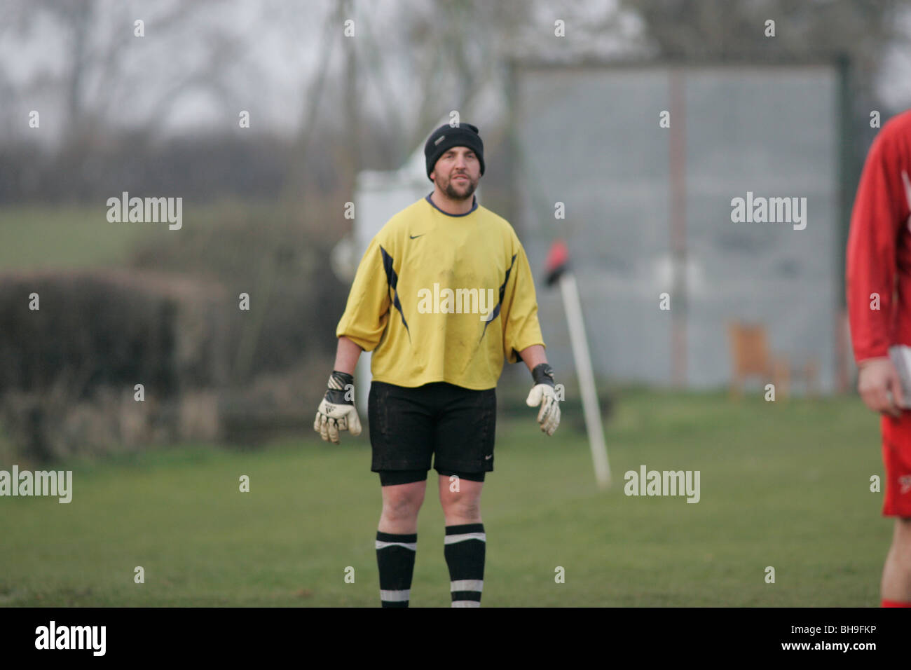 Lokalen Liga Fußball (Fußball) spielen Torwart hält warm durch das Tragen einer Wollmütze. Stockfoto