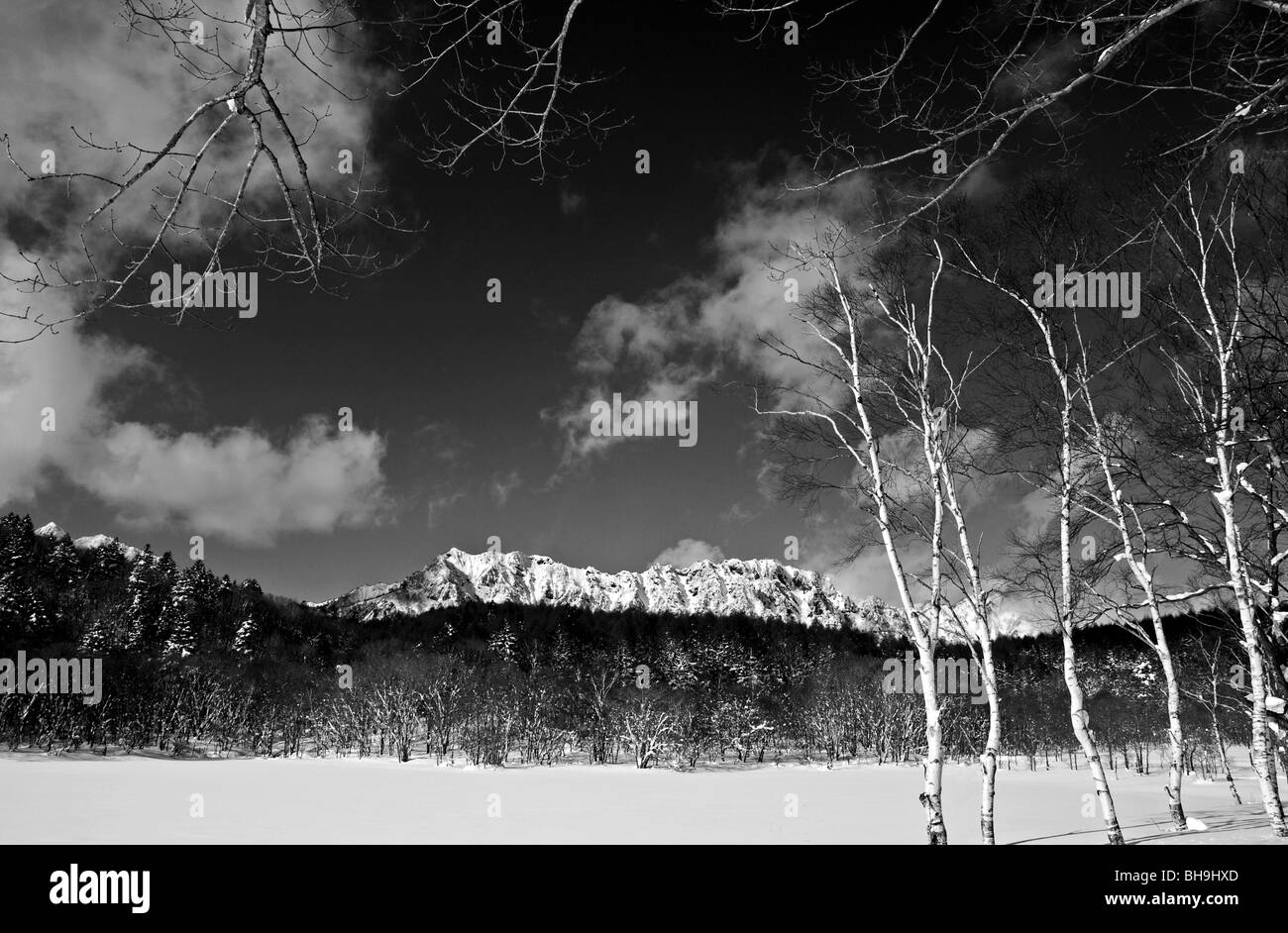 Hoher Kontrast Schwarz und Weiß stimmungsvolle Landschaft. Gefrorene Winter Lake in Japan mit Togakushi Berg und schneebedeckten Gipfeln im Hintergrund Stockfoto