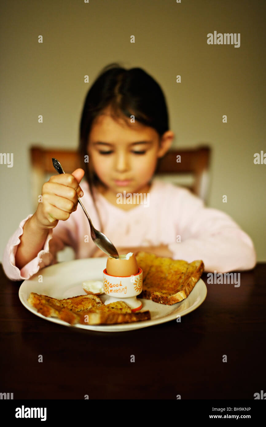 Fünf Jahre altes Mädchen isst gekochtes Ei zum Frühstück Stockfoto