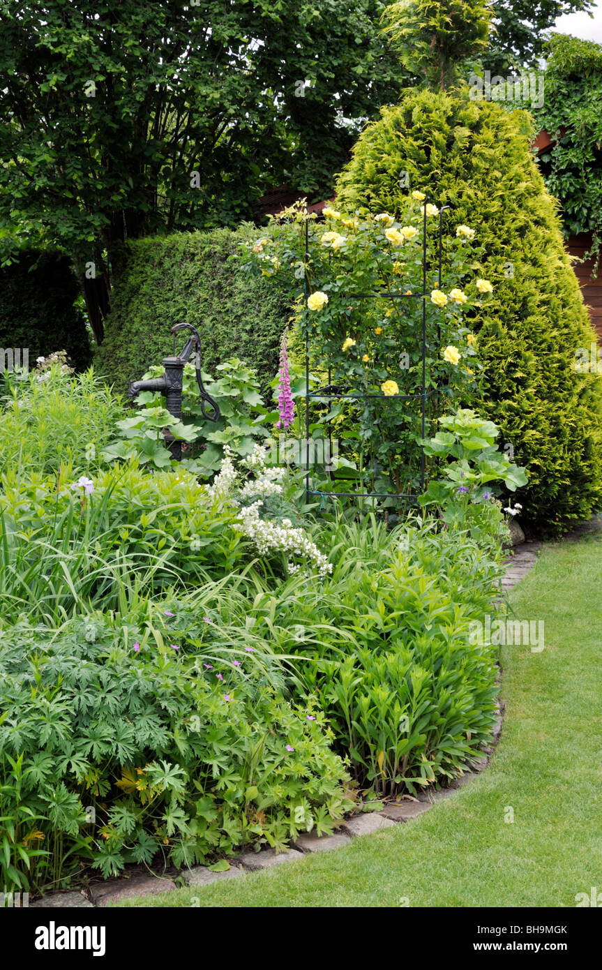 Mehrjährig Garten mit Klettern Rose und Strahl Pumpe. Design: Marianne und Detlef lüdke Stockfoto