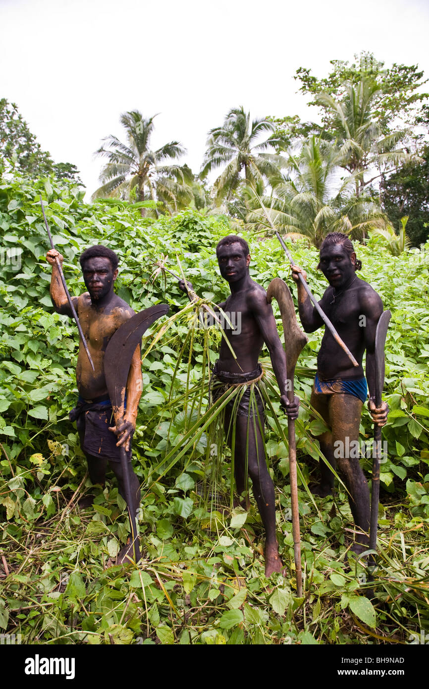 Drei melanesischen Männer posieren in Flora Insel mit traditionellen Waffen Stockfoto