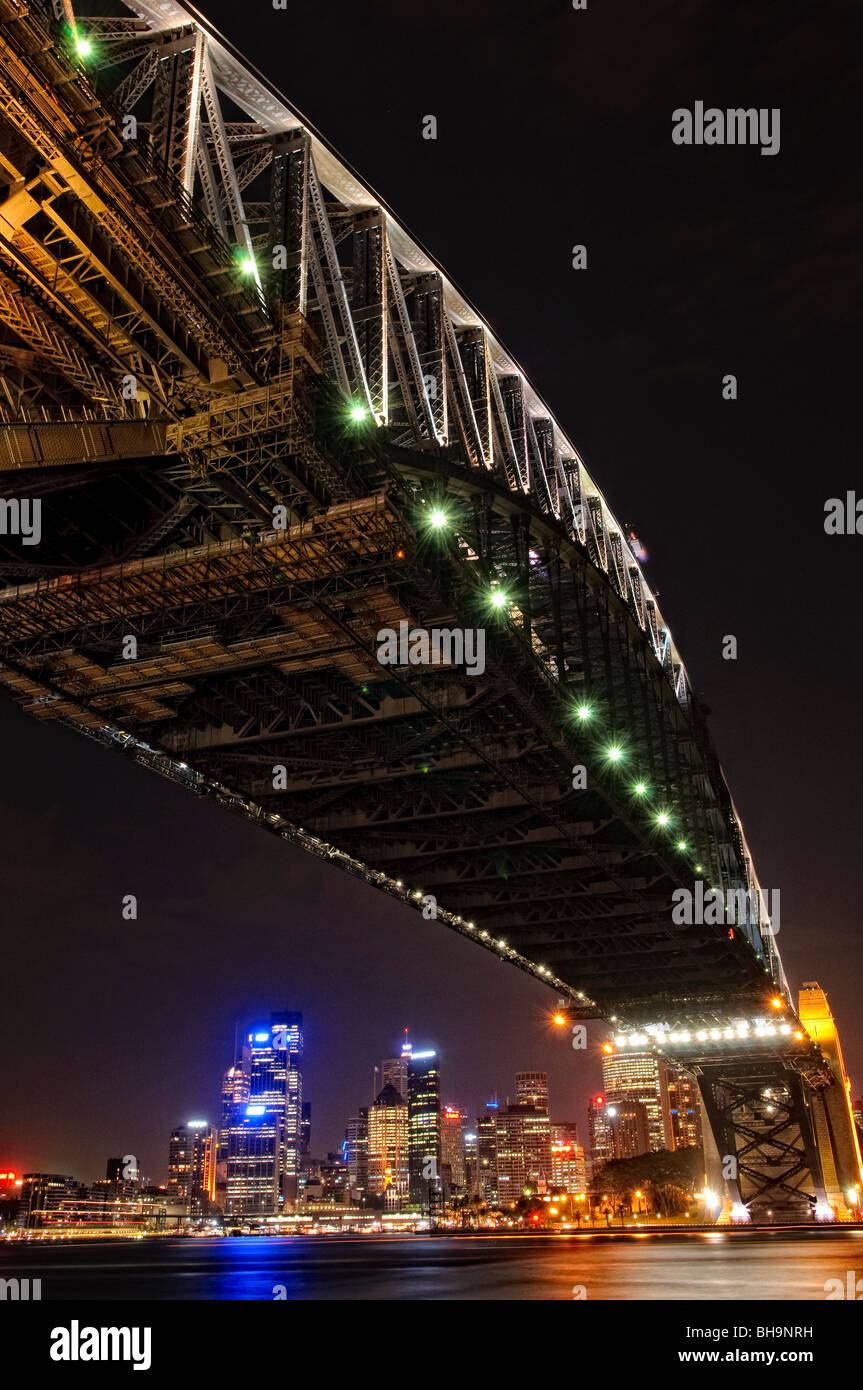 Sydney Harbour Bridge und City Skyline bei Nacht Sydney // SYDNEY, Australien – Nachtaufnahme der Sydney Harbour Bridge und Skyline der Stadt Sydney mit Blick zurück in Richtung Dawes Point und von Milsons Point. Die ikonische Brücke ist hell beleuchtet, und die pulsierenden Lichter der Stadt spiegeln sich auf dem ruhigen Wasser des Hafens von Sydney wider. Stockfoto