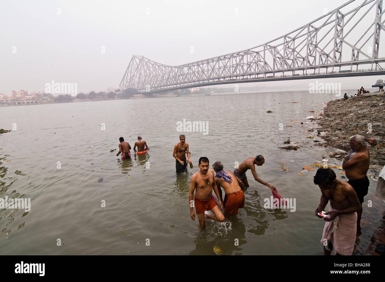 Pilger-Bad im Fluss Hooghly unterhalb der Howrah Brücke in Kalkutta. Stockfoto