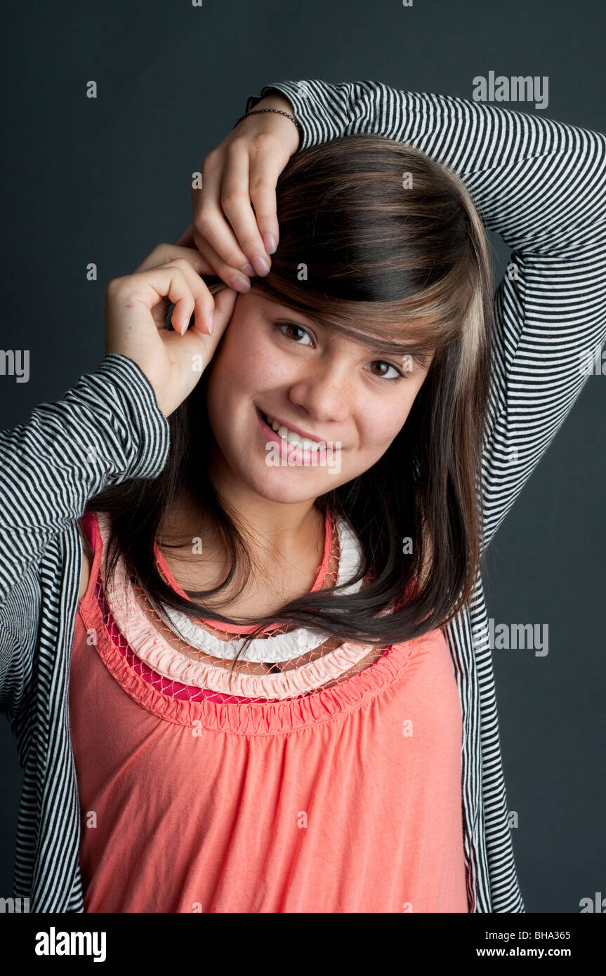 Ziemlich dreizehn Jahre altes Mädchen, die ihr Haar mit einem Haar Griff aufstellen Stockfoto