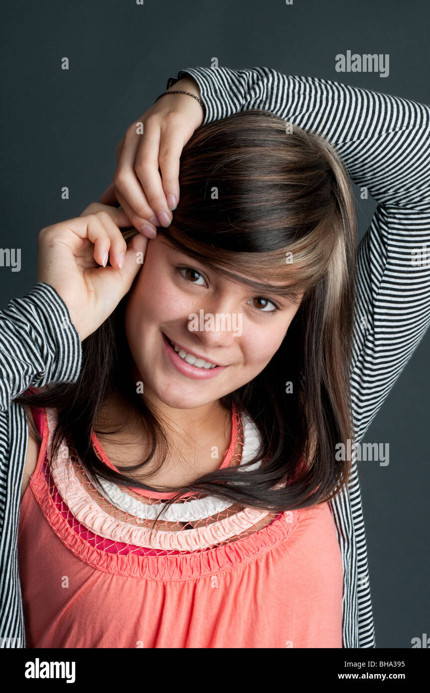 Ziemlich dreizehn Jahre altes Mädchen, die ihr Haar mit einem Haar Griff aufstellen Stockfoto