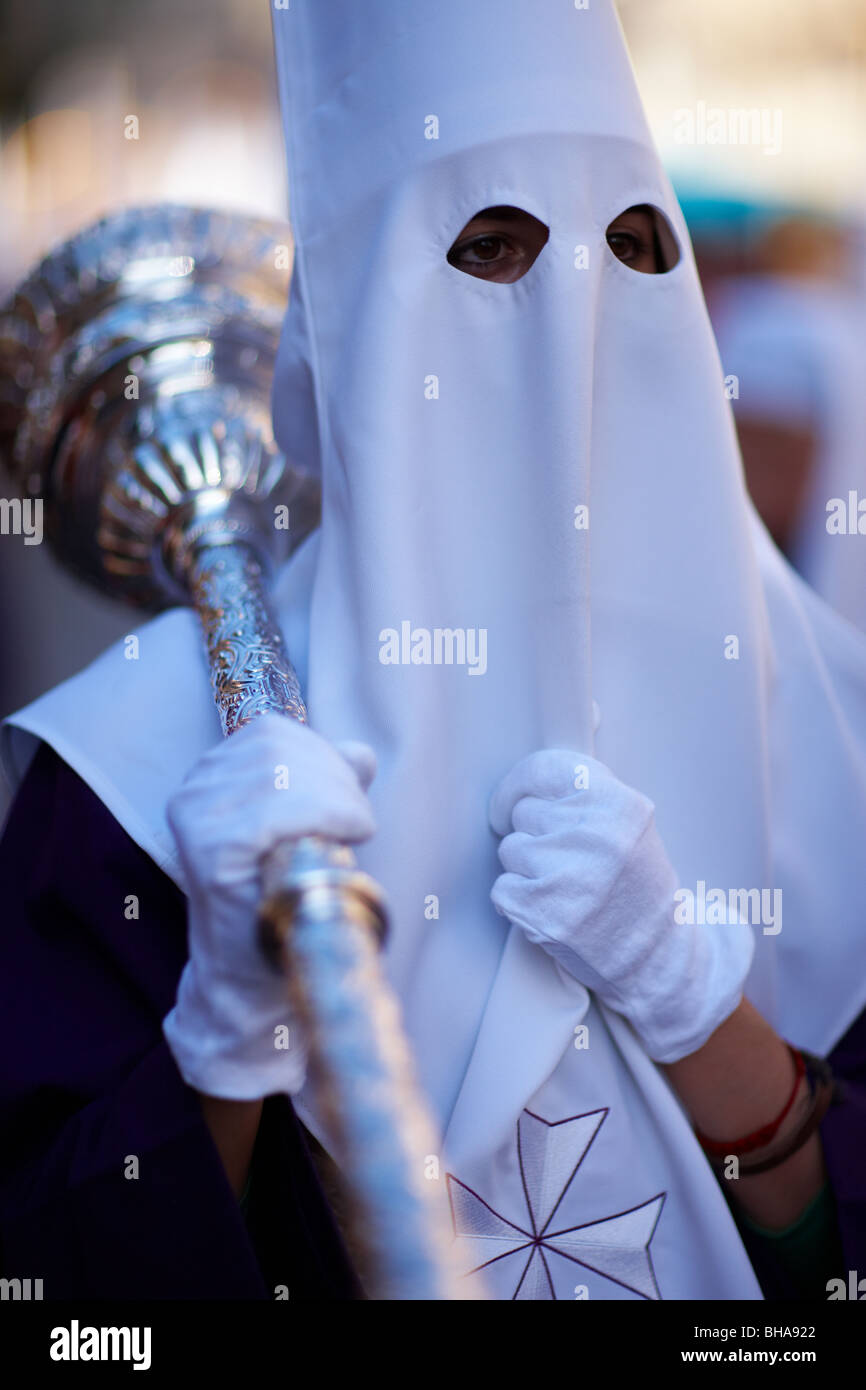 ein Büßer tragen eine Keule in der Semana Santa-Prozession in Malaga, Andalusien, Spanien Stockfoto