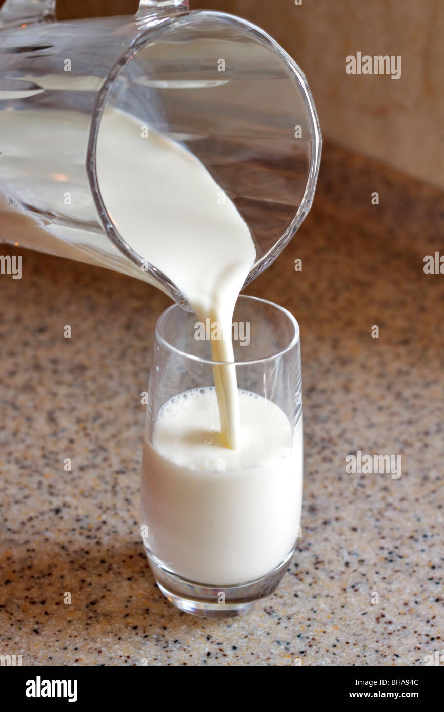 Gießen ein Glas Milch Stockfoto