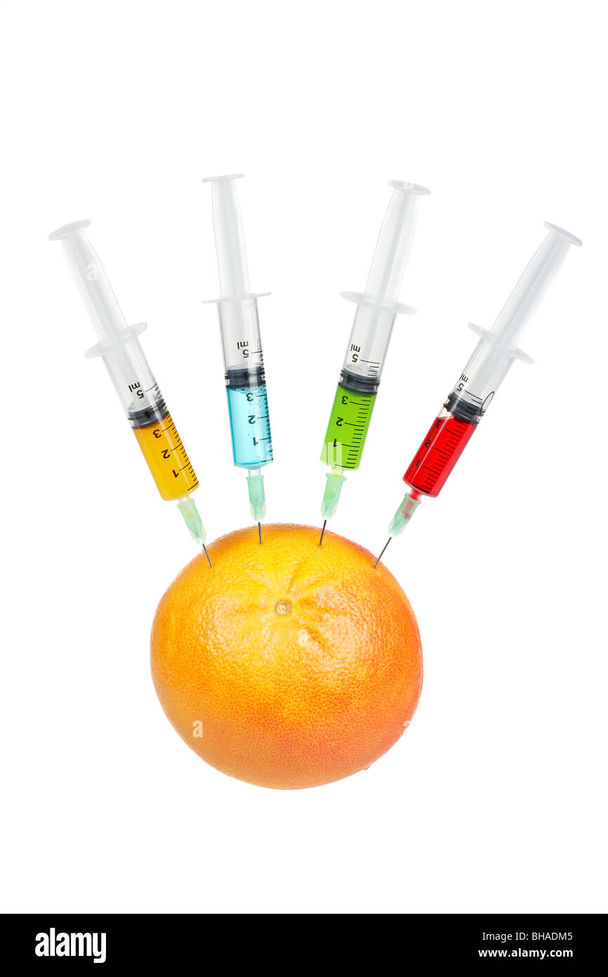 Eine Grapefruit mit vier Spritzen mit Farbe Flüssigkeiten, isoliert auf weißem Hintergrund injiziert werden. Geringe Schärfentiefe Stockfoto