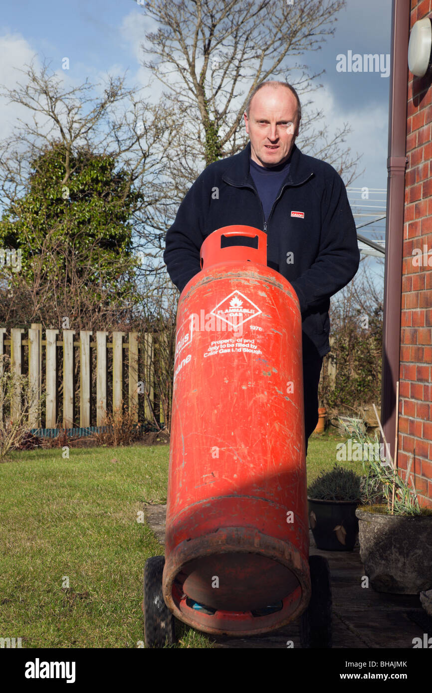 Man liefert einen inländischen Calor Gas Flasche Kanister auf einem Wagen. UK-Großbritannien Stockfoto
