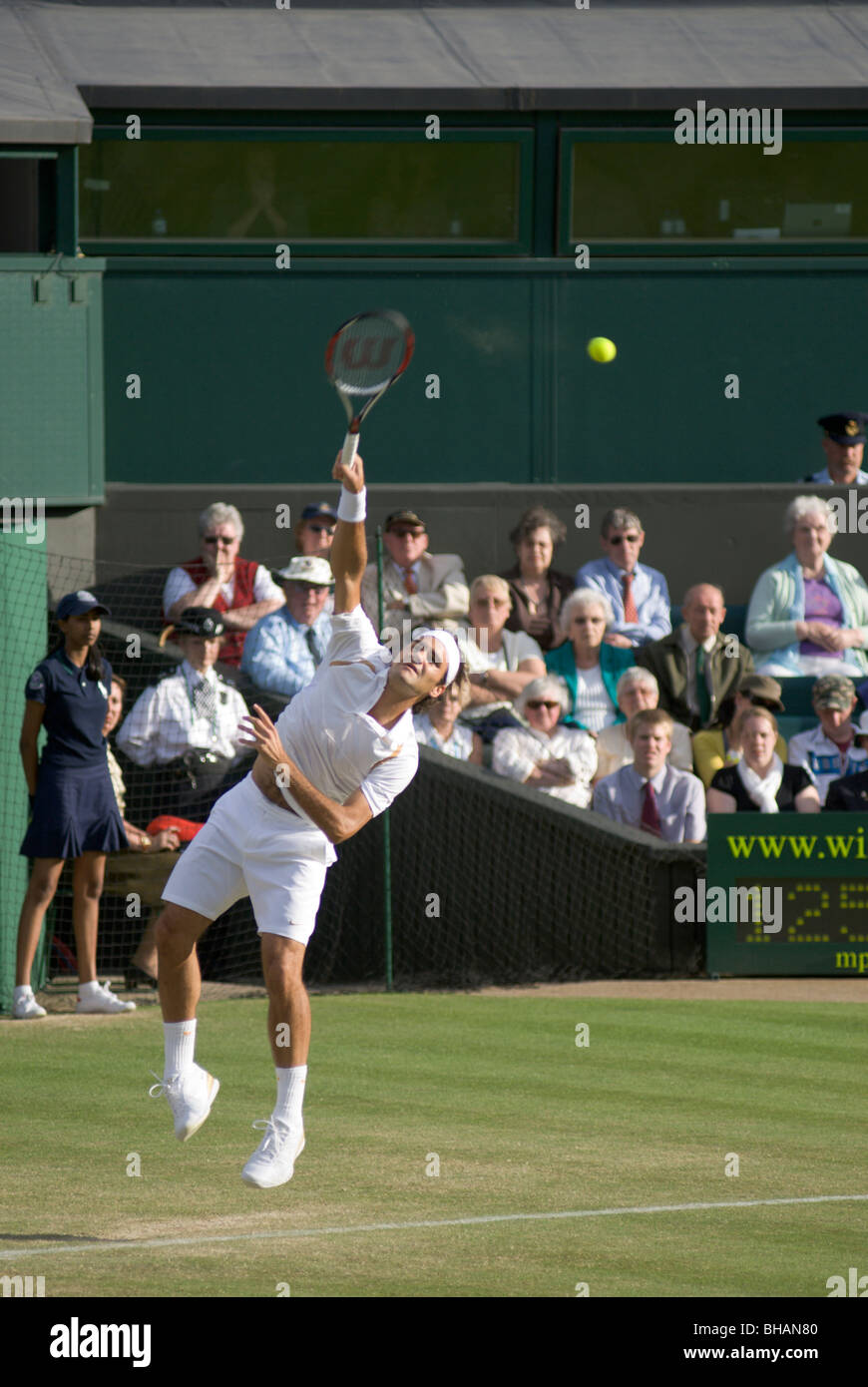 Roger Federer dient auf dem Centrecourt in Wimbledon. Stockfoto