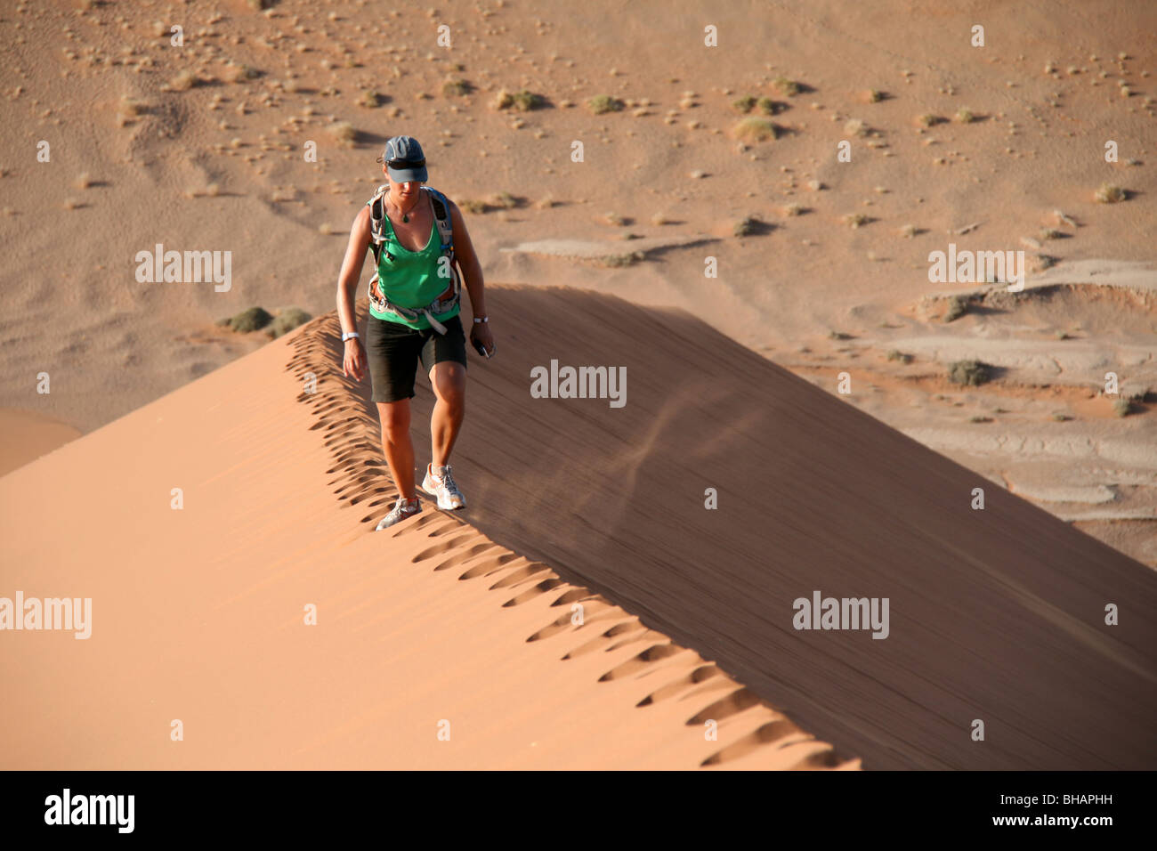 Wandern entlang der unberührten Grat einer riesigen roten Sanddüne in der Wüste von Namibia Stockfoto