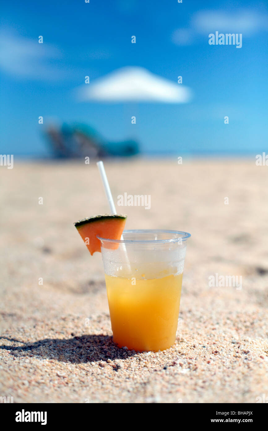 Cocktail am Strand - Liegestuhl, Sonnenschirm und blauen Himmel dahinter. Stockfoto