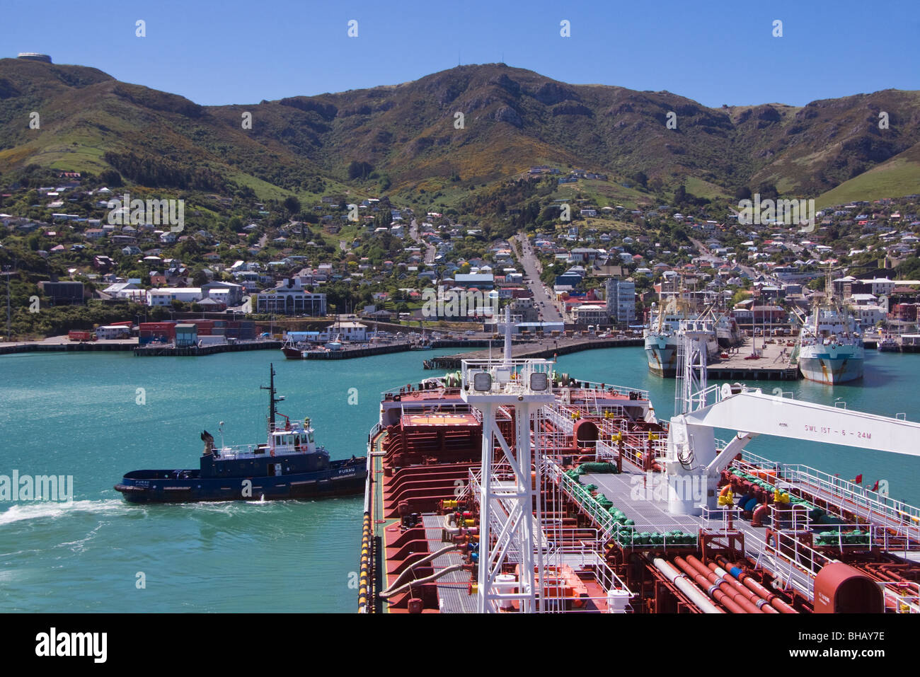 Ein Ruck schiebt am Bug ein Tanker hilft es sich im inneren Hafenbecken, Lyttelton, Neuseeland Stockfoto
