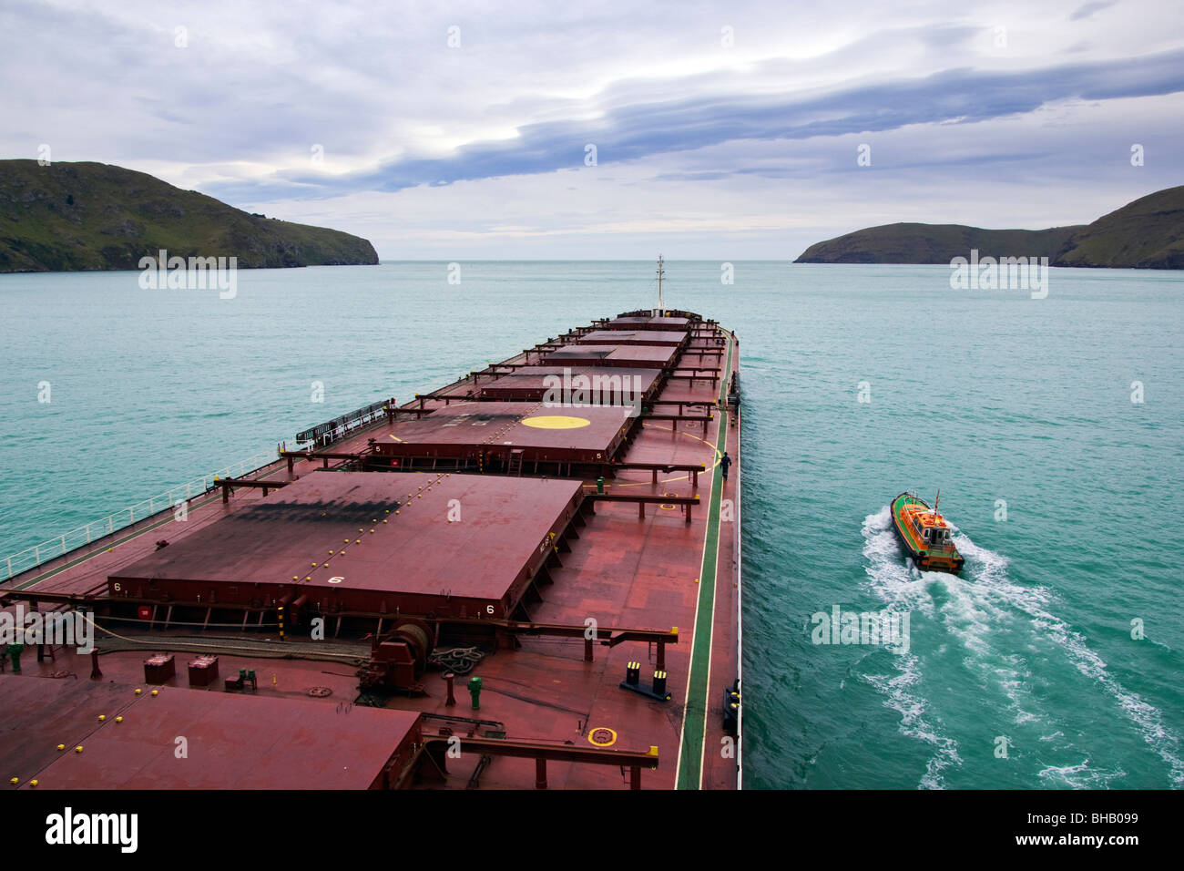Eine große Massengutfrachter fährt vom Hafen und das Lotsenboot wartet neben der Pilot auszuziehen. Stockfoto