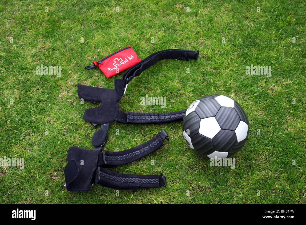 Fußballer Knie Orthese legt neben einem Fußball und erste Hilfe Kit vor Spiel Stockfoto