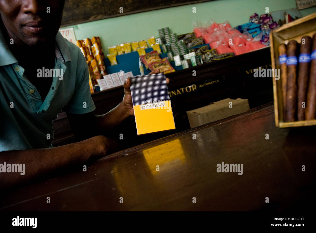 Eine kubanische Mann bietet eine Fälschung der Cohiba Zigarren unter-the-Counter in eine staatliche Lebensmittel-Laden in Havanna, Kuba. Stockfoto