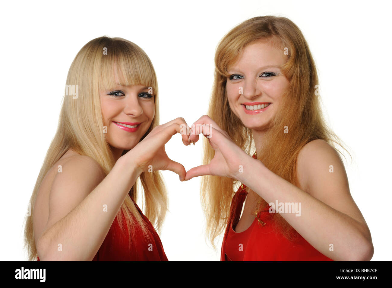 Zwei Mädchen mit die abstrakte Form des Herzens, die mit Händen gemacht. Es ist auf einem weißen Hintergrund isoliert. Selektiven Fokus Stockfoto