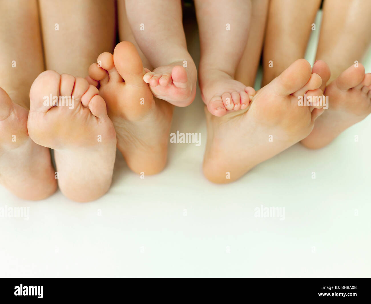 Eine Reihe von nackten Füßen auf einem weißen Blatt Stockfoto