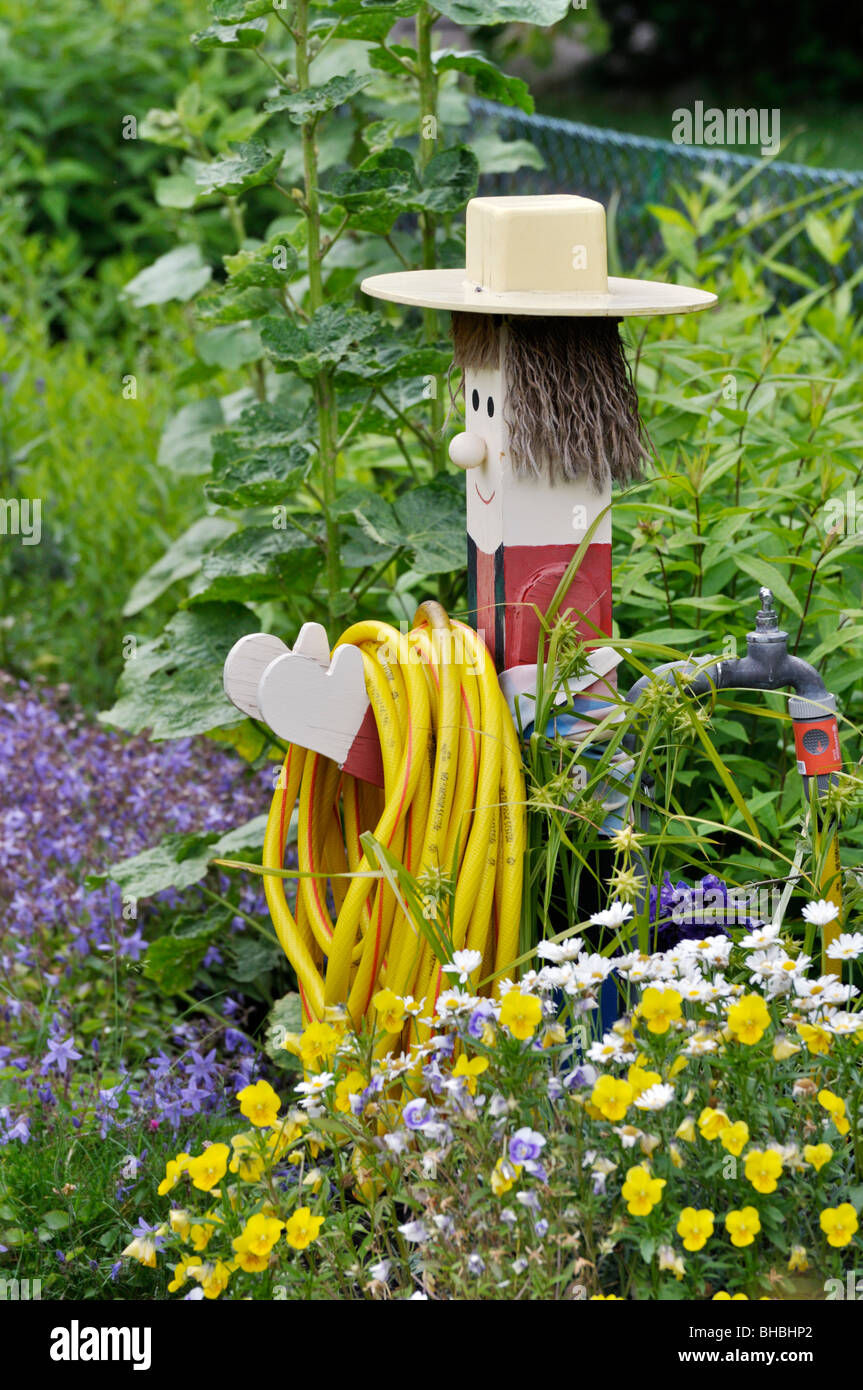 Holzfigur mit einem Wasserschlauch Stockfoto