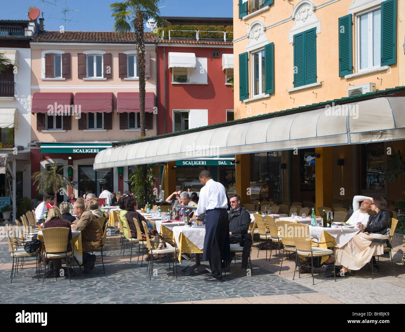 Sirmione, Lombardei, Italien. Kellner servieren Kunden auf ein Straßencafé mit Blick auf den Gardasee. Stockfoto