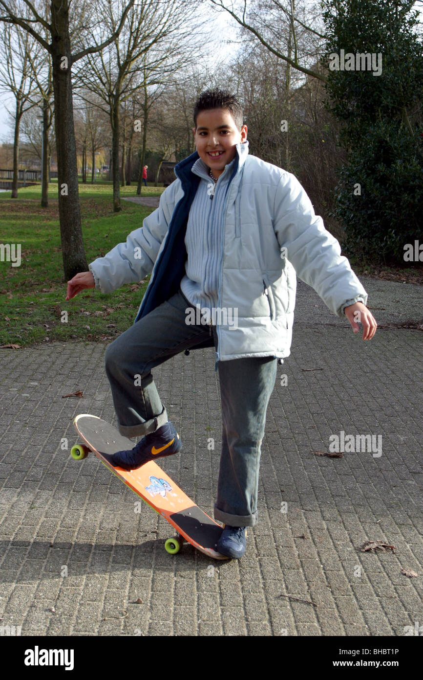 Fröhlichen Teenager voller Länge mit Skateboard zeigen einfache Anfänger  Skate Board Trick draußen im Winter tragen Stockfotografie - Alamy
