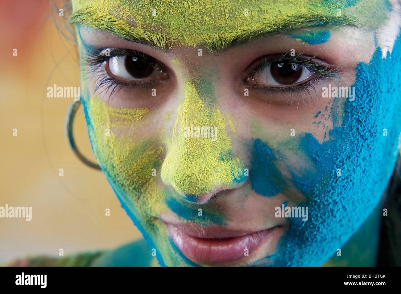 Weibliches Gesicht bedeckt in Holi Farben Stockfoto